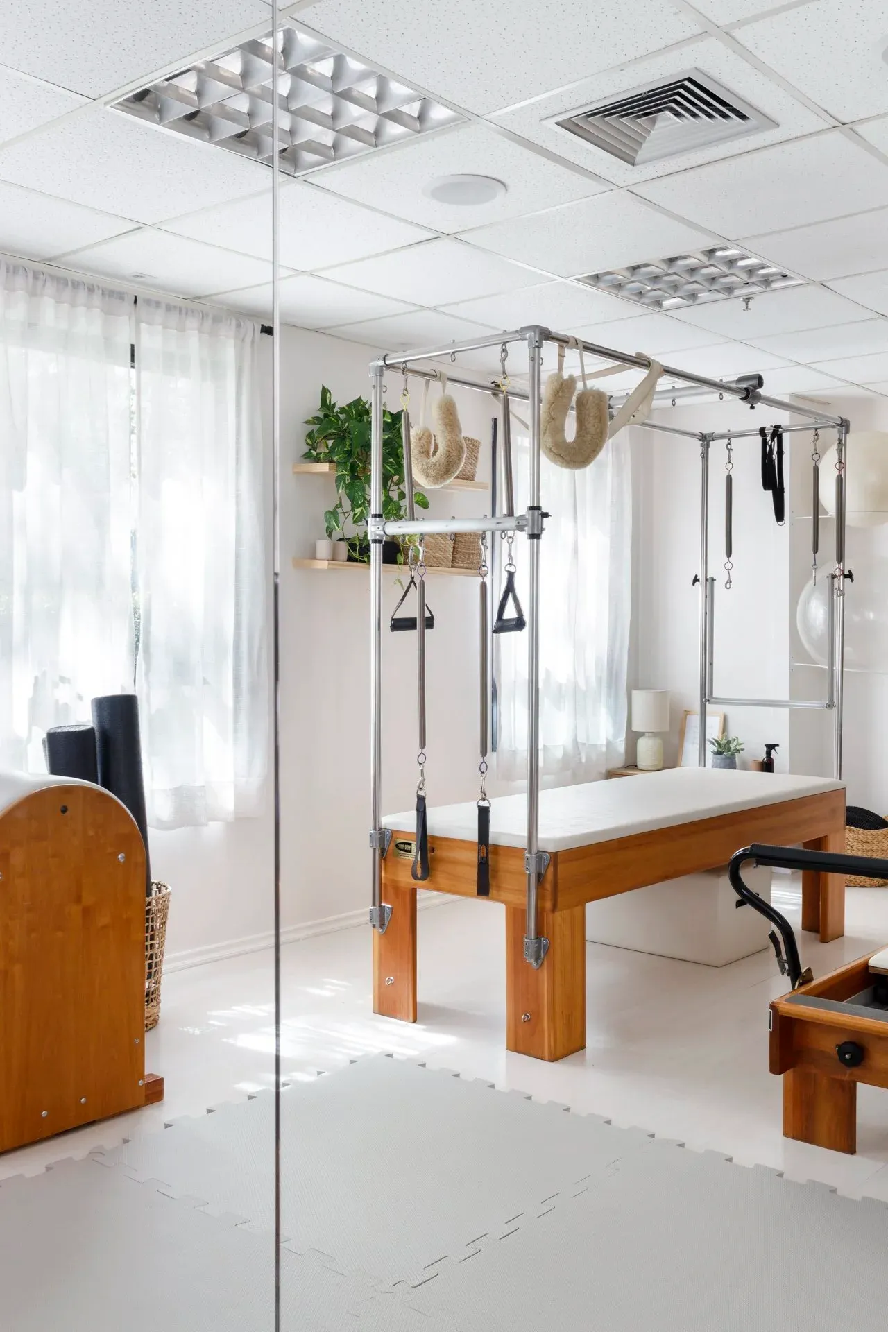 Cadillac de madeira em sala clara com espelhos e janelas com cortinas brancas