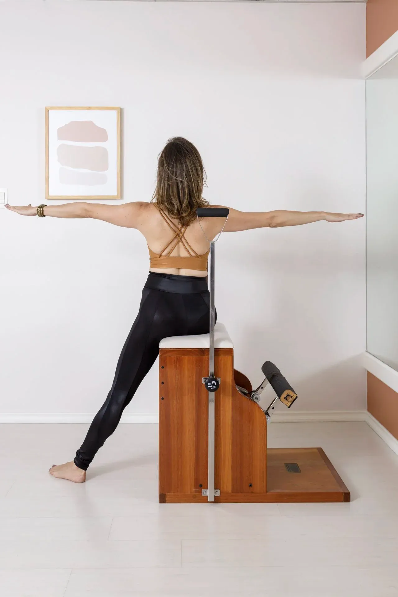 Aluna de costas no wunda chair com braços abertos para equilíbrio