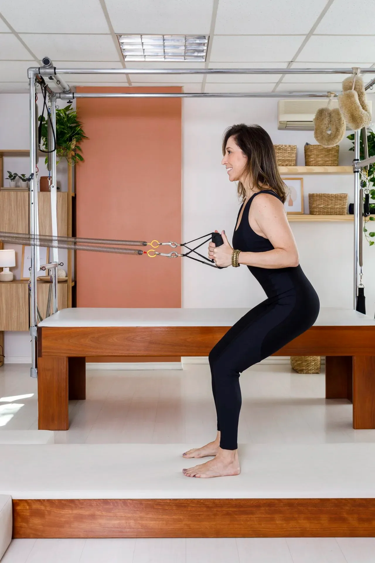 Aluna realizando exercício de Pilates no aparelho